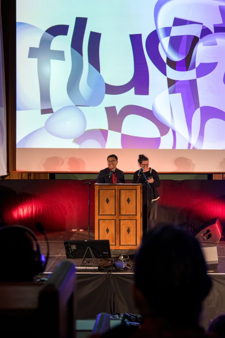 Zwei Personen auf einem Podium, im Hintergrund fluctoplasma Visual.